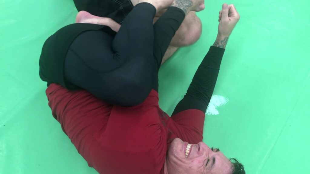 Stepping inside butterfly hooks to set up a straight ankle lock